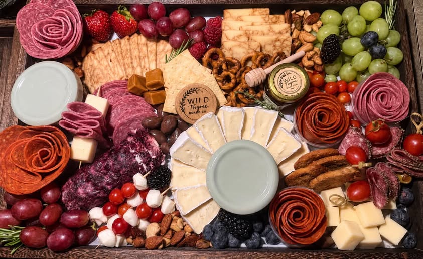 A grand Wild Thyme grazing board filled with cured meats, cheeses, fruit, and accompaniments